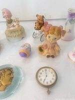 Group view showing majority of items including figurines, egg, paperweight and clock