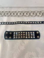 Chainmail belt (top), narrow studded strap (middle), wide studded cuff (bottom) laid out for overview