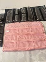 Pink and black organizers folded open showing zip pockets