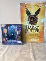 Boxed Harry Potter action figure beside rolled poster in sleeve