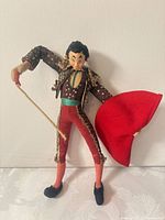 Front view of Roldan matador doll holding cape and rod
