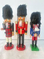 Front view of all three nutcracker figurines showing size comparison and uniforms