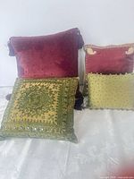 Group shot of all four decorative pillows showing colors, sizes and embellishments