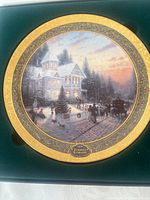 Porcelain plate inside presentation box, full view of artwork and gold rim