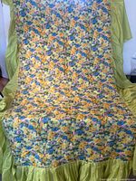 Full view of bedspread showing floral quilt body and green ruffle