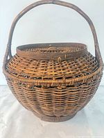Top view of round wicker basket showing lid and handle