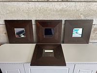 Four dark wood framed mirrors displayed