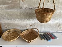 All three wicker baskets and six boxed collector spoons on surface