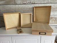 Group view showing storage box with lid, two trays, art panel, and bottle opener plaque