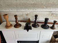 All five candle holders, metal apple and partial view of taiaha on mantel