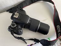 Camera body with telephoto lens and strap