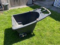 Side view of black resin yard cart showing wheels and handle