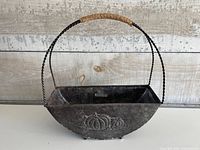 Front view showing planter shape, handle, pumpkin relief