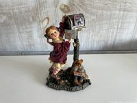 Front view of figurine showing girl, mailbox, teddy bear, base inscription