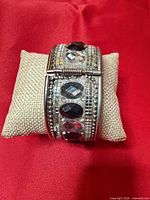 Front view of bracelet on display pillow showing stone layout and width