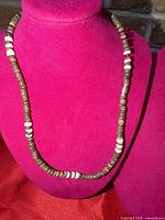 Full view of wooden bead necklace on display bust