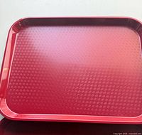 Top view of cranberry red Cambro tray showing textured surface and raised rim