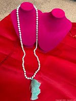 Full view of necklace draped on display forms showing overall length and bead design