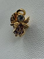 Front view showing gold-tone angel pin and rhinestone details