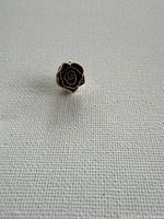 Front view of black enamel rose tie tack