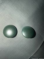 Front view of both light blue round clip-on earrings