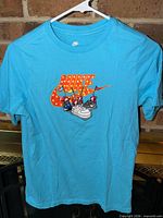 Full view of front of blue Nike T-shirt on hanger