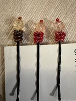 Front view of three decorative bobby pins on product card