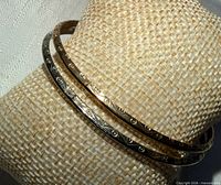 Gold-tone and silver-tone bangles on display pillow