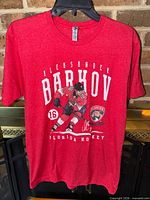 Front view of red Alexander Barkov Florida Panthers T-shirt on hanger