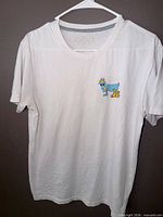 Front view of white GOAT USA T-shirt showing small chest graphic