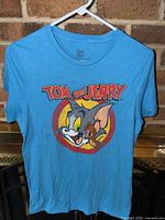 Front view of blue Tom & Jerry graphic T-shirt on hanger