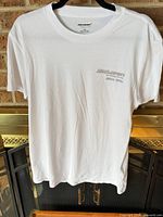 Front view of white Hollister McLaren T-shirt hanging on hanger