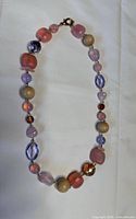 Full view of necklace laid flat showing bead variety and clasp