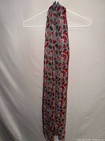 Full view of long gray scarf hanging to show length and overall pattern