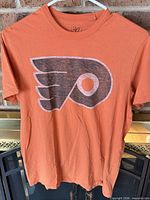 Front view of orange T-shirt with Flyers logo