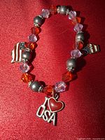 Full view of bracelet showing bead colors and all three charms