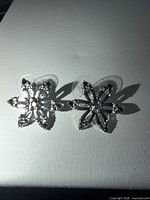 Front view of pair of silver-tone snowflake earrings with diamonds