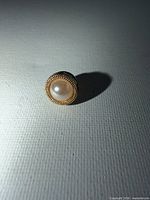 Front view showing pearl cabochon and gold-tone bezel