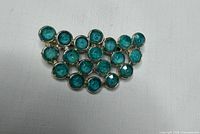 Front view showing arrangement of nineteen blue cabochon stones in gold-tone frame