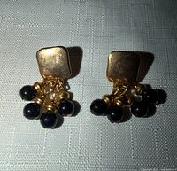 Front view showing square gold-tone studs and black bead dangles