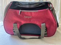 Front view of Bergan pink pet carrier showing logo, mesh panel, handles, zippered pocket