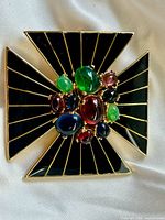 Front view showing enamel arms and cabochon cluster