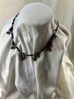 Full view of necklace draped on bust showing bead clusters and overall shape