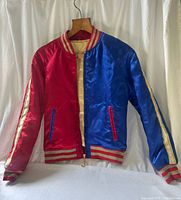 Full view of front showing red and blue panels, zipper, collar, cuffs, waistband
