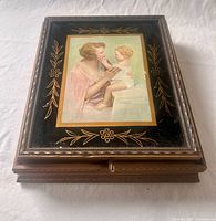 Closed box top showing print, gilded edge and black panel