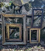 Five frames leaning against rock wall