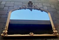 Front view of large gold-framed mirror showing full frame and reflection