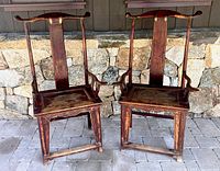 Front view of pair showing yokeback crest rails, seats and arms