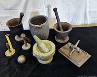 Group view showing all mortars, pestles, railroad spikes, jack sculpture and planter