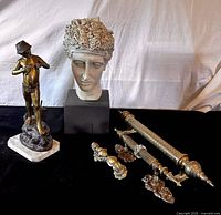 Group shot of all five items: fisherboy statue, athlete bust, two towel rods, door knocker